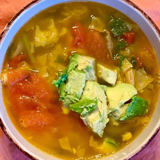 Cabbage veggie soup topped with avocado