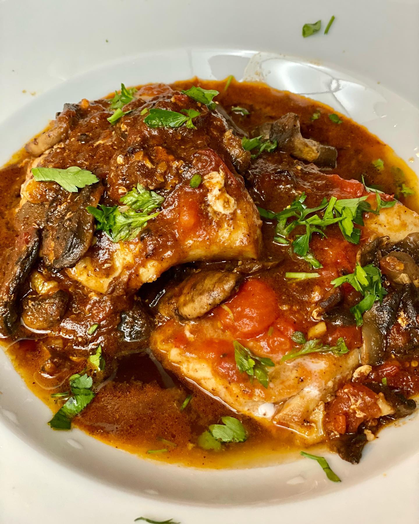 CAJUN GARLIC BUTTER COD in tomato mushroom sauce.