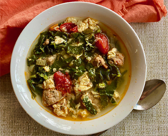 Joyful Italian Wedding Soup with Meatballs and Kale Leaves
